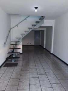 Habitación vacía con escaleras y suelo de baldosa. en Casa Sérgio, en Itajaí