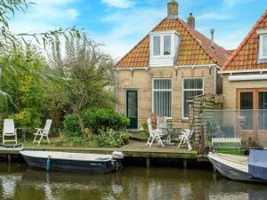 een huis op het water met een boot voor bij Modern holiday home in Heeg with garden in Heeg