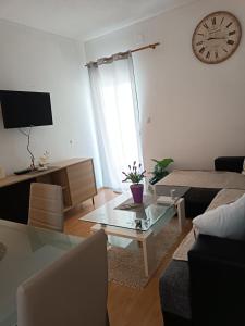 ein Wohnzimmer mit einem Couchtisch und einer Uhr an der Wand in der Unterkunft Apartment "San Marino" in Baška Voda