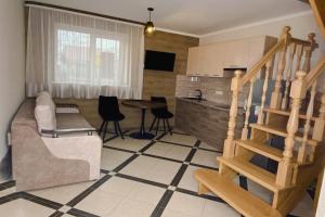 a living room with a staircase and a table at Вілла Aqua Shayan in Shaian