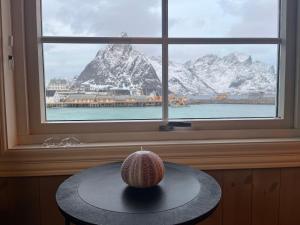 une table avec une bougie devant une fenêtre dans l'établissement Rostad Retro Rorbuer, à Reine