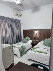 a hotel room with two beds and a window at Hotel Royal Plaza in Florencia