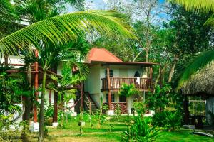 gruwelijk huis met een balkon en palmbomen bij La Choza Playa Venao in Playa Venao