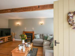 een woonkamer met een bank en een tafel bij Grove Farm Cottage in Condover