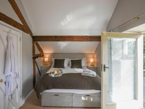 a bedroom with a large bed and a window at Grove Farm Cottage in Condover