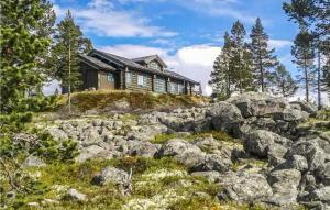 a house on top of a hill with rocks at Nice Home In Rendalen With Sauna And 4 Bedrooms in Rendalen