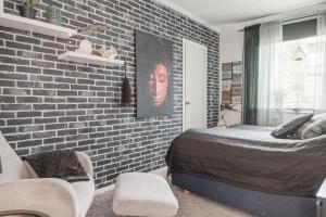 Un dormitorio con una pared de ladrillo y una cama en Guestly Homes - 4BR City Center Apartment en Piteå