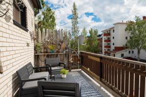 a balcony with two chairs and a table and a fence at Guestly Homes - 4BR City Center Apartment in Piteå