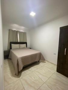 1 dormitorio con 1 cama en una habitación blanca en Britanic Home, en Maragogi