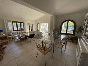 a living room with a glass table and chairs at Villa Can Llompart Port de Pollensa in El Port