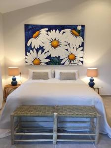 a bedroom with a bed with a painting of daisies at Villa Can Llompart Port de Pollensa in El Port +16 photos