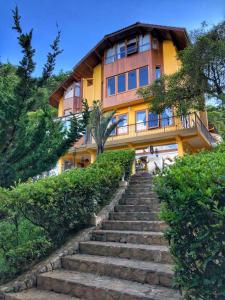 una casa con escaleras que conducen a ella en Carícia do Vento Pousada Boutique, en Monte Verde