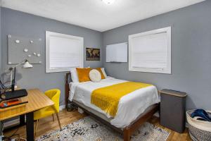 una camera da letto con un letto, una scrivania e due finestre di Entire Cute Boho Home Near Hospital, Expo Center, Free Parking a Kalamazoo