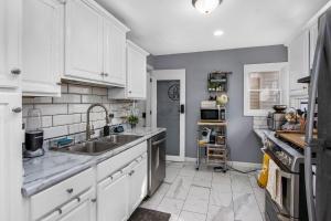 una cucina con mobili bianchi e un lavandino di Entire Cute Boho Home Near Hospital, Expo Center, Free Parking a Kalamazoo