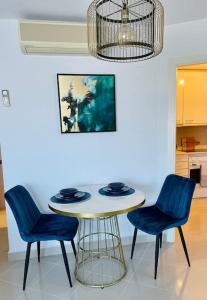einen Tisch und zwei blaue Stühle in einer Küche in der Unterkunft Couples Only, beautiful 1 Bedroom Apartment in Victoria Building in Mojácar