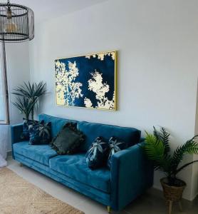 ein blaues Sofa mit schwarzen Kissen im Wohnzimmer in der Unterkunft Couples Only, beautiful 1 Bedroom Apartment in Victoria Building in Mojácar