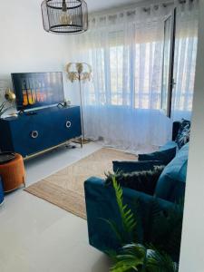 a living room with a blue couch and a tv at Couples Only, beautiful 1 Bedroom Apartment in Victoria Building in Mojácar