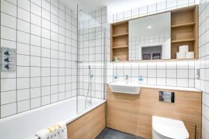 a bathroom with a sink and a tub and a toilet at Pluxa Onyx Luxury 1 bedroom apartment in Birmingham