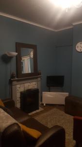 un salon avec une cheminée et un miroir dans l'établissement Atlantic cottage, à Blackpool 4 autres photos