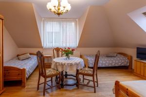 a room with two beds and a table with chairs at Pensjonat nad Płaskim in Jerzwałd