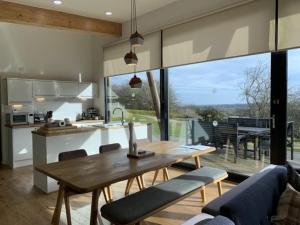 cocina y sala de estar con mesa de madera y sillas en Yorkshire Dales Lodge 17 Premium Ensuite en Richmond