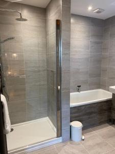 uma casa de banho com um chuveiro e uma banheira em Yorkshire Dales Lodge 18 Premium Family em Richmond