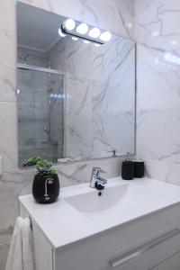 Un baño blanco con lavabo y espejo. en Estudio Playa Los Locos, Torrevieja, en Torrevieja