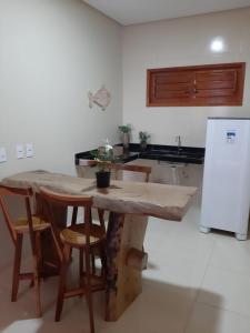 a kitchen with a table and chairs and a refrigerator at Pousada Makai - Cajueiro da Praia in Barra Grande