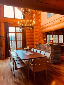 una sala da pranzo con tavolo, sedie e lampadario pendente di Chalet Caprea a Bad Kleinkirchheim