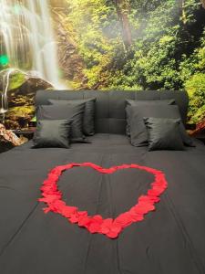 a bed with a heart on it in front of a waterfall at Aux trois univers in Verviers