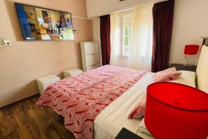 1 dormitorio con 1 cama y 1 silla roja en Excelente Casa c/ Pileta Cerca del Centro en Villa Carlos Paz