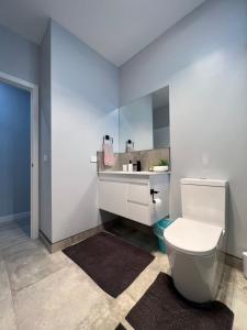 een badkamer met een wit toilet en een wastafel bij Howrah Getaway (Entire Place, Private Entrance, Breakfast included) in Howrah