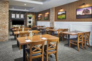 a restaurant with wooden tables and chairs and a tv at The Hotel Landing in Wayzata