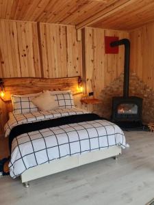 a bedroom with a bed and a wood stove at CENNET DAĞ EVİ in Ayder Yaylasi
