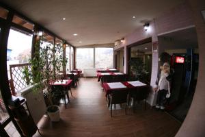 Rooms&Restaurant 43 في بلغراد: امرأة تقف داخل مطعم مع طاولات