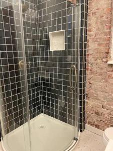 ein Bad mit Dusche und schwarz gefliesten Wänden in der Unterkunft Brick Street Apartment-Studio Suite in Augusta