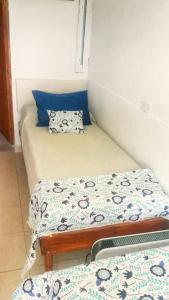 um pequeno quarto com 2 camas individuais e uma almofada em Posada La Sofia em Tafí del Valle