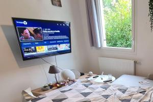 Schlafzimmer mit einem Bett und einem TV an der Wand in der Unterkunft Joli Appartement vue montagne, cosy avec jardin in Bonneville