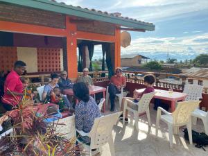 a group of people sitting at tables on a patio at Maison d'Accueil - Fondation San Filippo Neri in Bujumbura