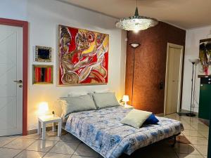 a bedroom with a bed and a painting on the wall at Amarin Pisa Apartment in Pisa