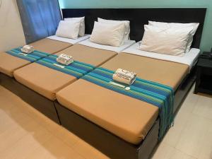 dwa łóżka siedzące obok siebie w pokoju w obiekcie Coron Visitors Hotel w mieście Coron