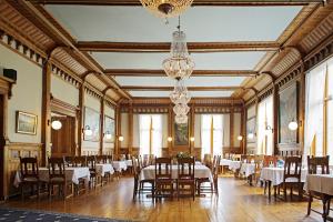 a dining room with tables and chairs and a chandelier at Thon Hotel Sandven in Norheimsund