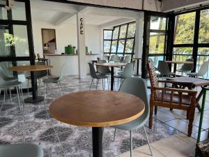 un restaurante con mesas, sillas y ventanas en Tekoa Spaces, en San Antonio Palopó