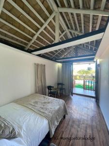 1 dormitorio con 1 cama y suelo de madera en Angostura Lodge 