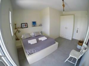 um quarto com uma cama com duas almofadas e uma cadeira em KVilla Comfort Living em Triandáros