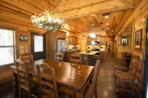 a dining room and kitchen with a wooden table and chairs at HochaHoma Luxury Cabin in Broken Bow