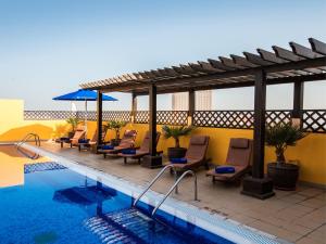 a patio with chairs and a swimming pool at Citymax Hotel Al Barsha at the Mall in Dubai