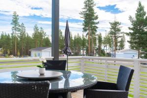 patio con tavolo, sedie e ombrellone di Beautiful house with sea view a Piteå