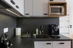 cocina con fregadero y microondas en Apartament przy PILECKIEGO 34 en Biała Podlaska