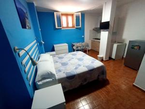 um quarto azul com uma cama e uma mesa em Guest House Albergabici La Cattedrale em Barletta